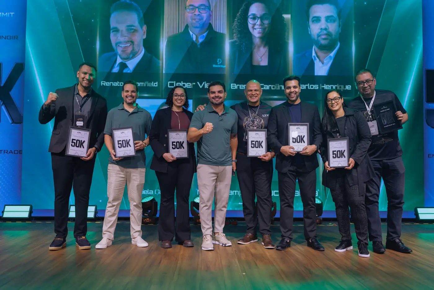 Turma de traders no palco segurando as placas de 50K