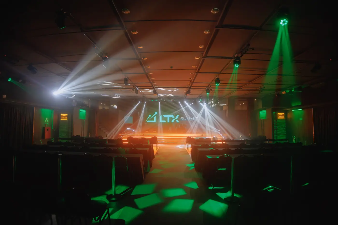 Salão vazio antes da abertura, com luzes verdes e o logo do LTX Summit