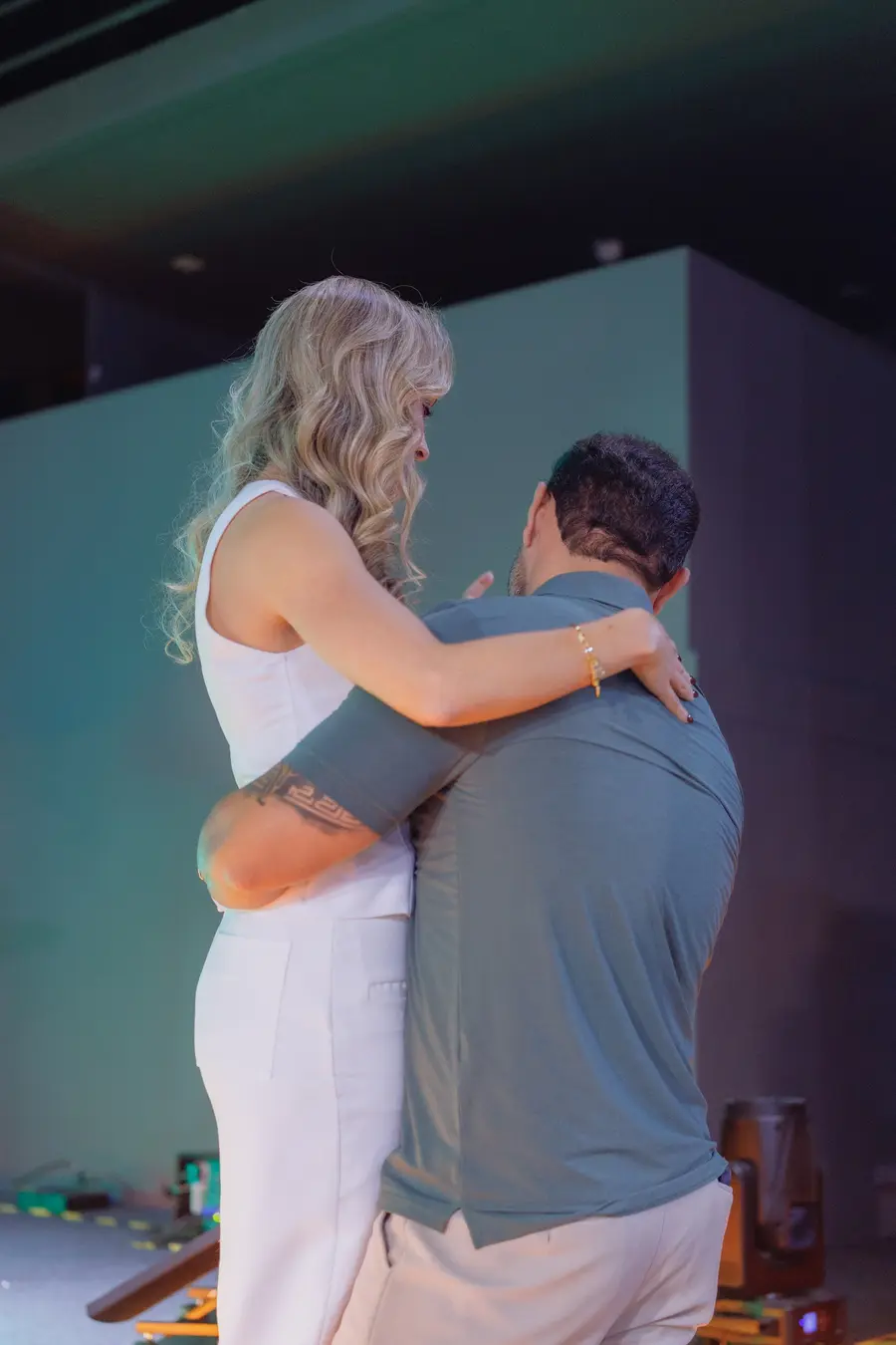Mulher abraçando um homem com força no palco