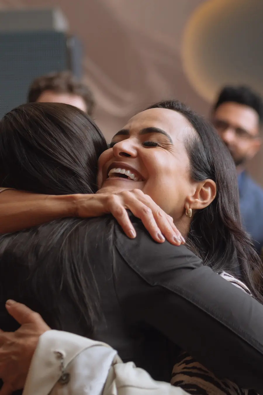Participante sorrindo durante um abraço na chegada